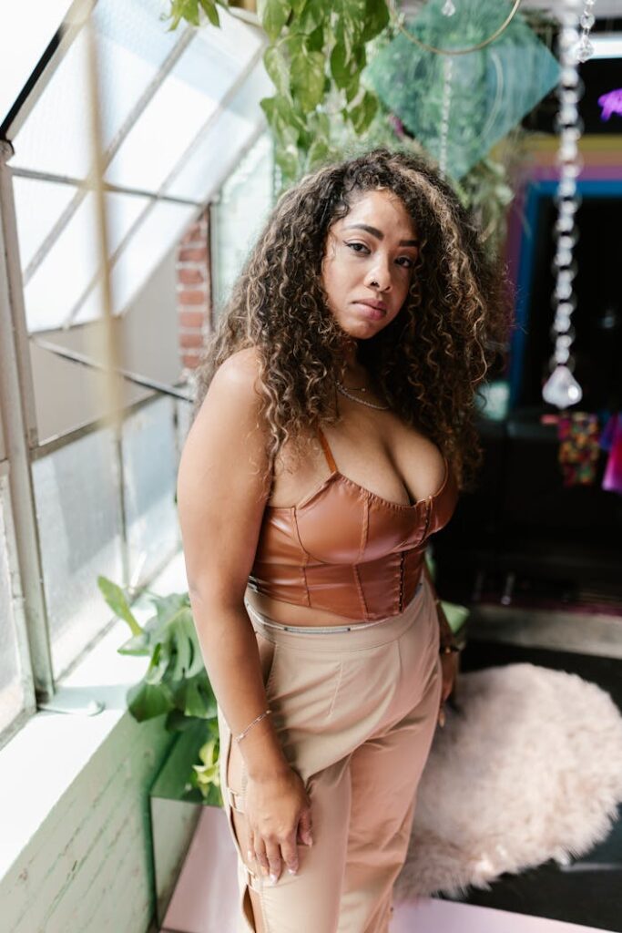 Portrait of a plus size woman posing confidently in fashionable attire indoors.